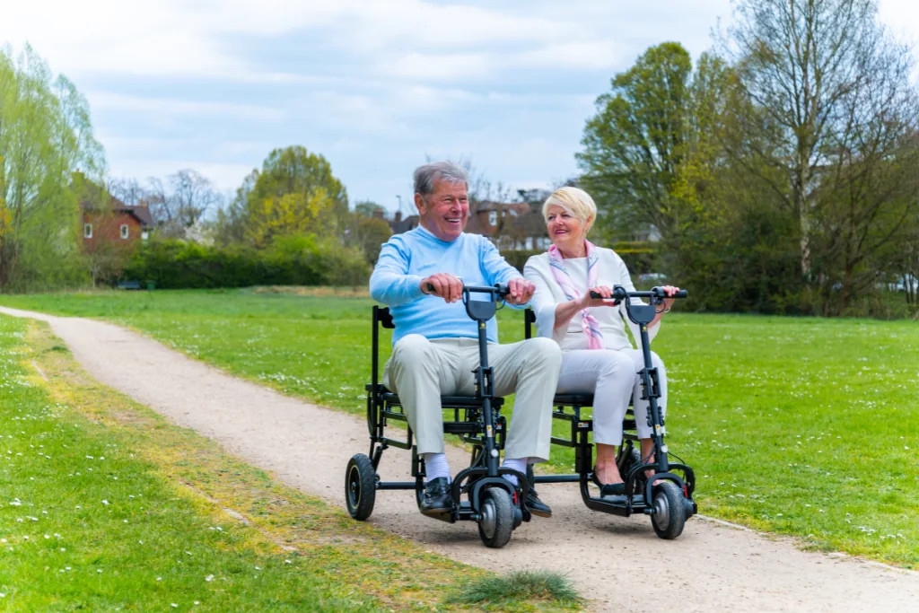 Couple riding eFOLDi scooters together through a park